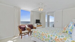 Ein Schlafzimmer mit Bett, Fernseher, Deckenventilator und Meerblick.