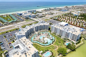 Un complex turístic amb diverses piscines, una platja i un moll.