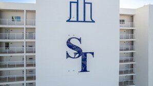 En bygning med en hvid facade og et stort, blåt 'ST' skilt.