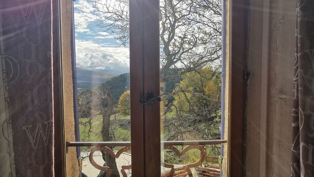Una stanza con un'ampia finestra che si affaccia su un paesaggio montano.