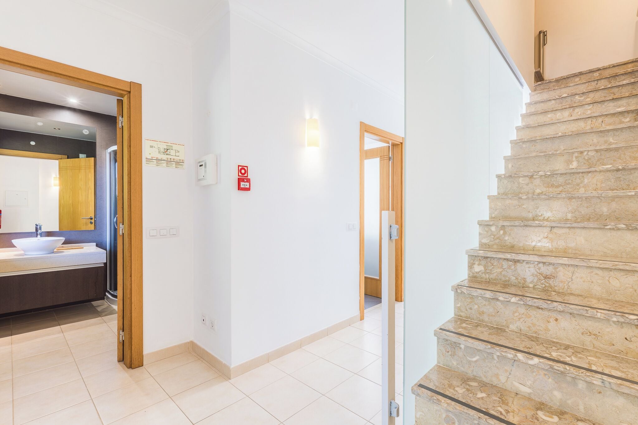 L’intérieur d’un hôtel, avec une salle de bain, un escalier et un couloir.