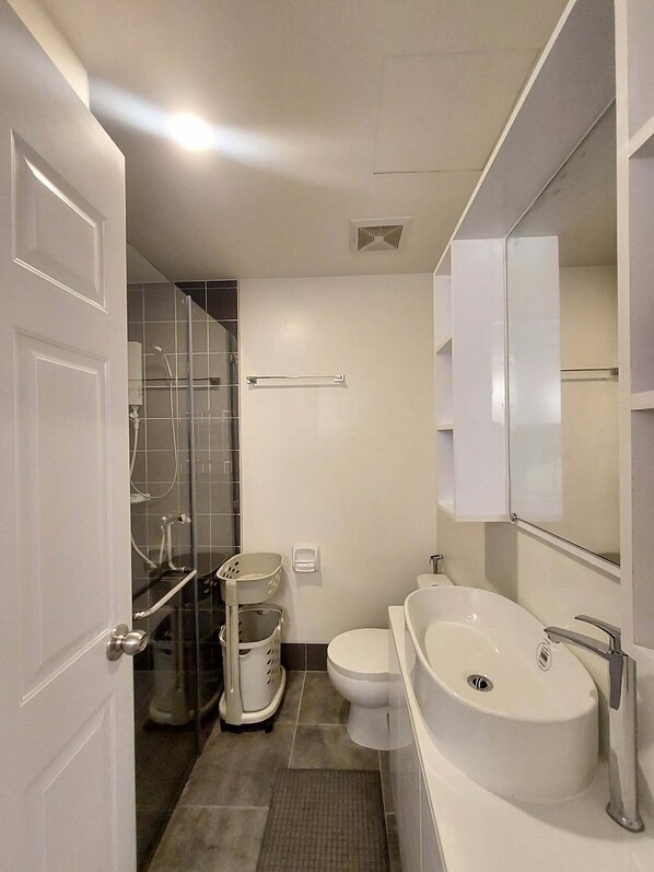 Une salle de bain moderne équipée d’une douche, de toilettes et d’un lavabo.