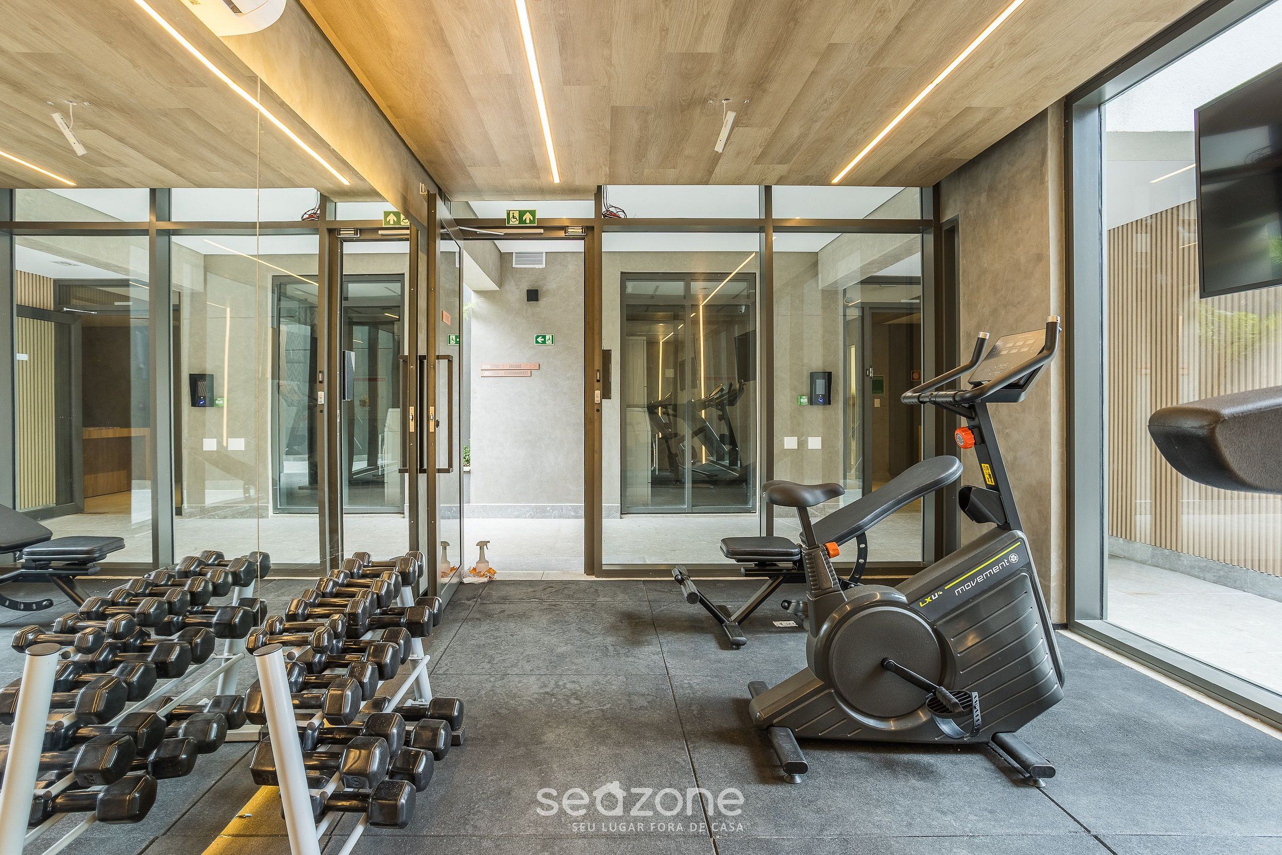 A gym with exercise equipment, including dumbbells and an elliptical machine.