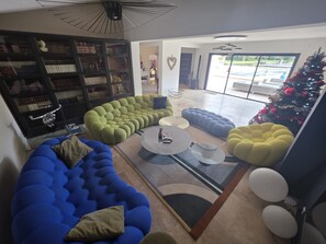 A modern living room with a sectional sofa, a coffee table, and a Christmas tree.