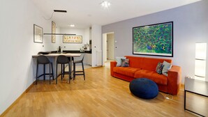 Un espace de vie moderne comprenant une cuisine, un coin repas et un grand tableau accroché au mur.