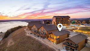 A resort with multiple buildings, outdoor seating areas, and a view of the water. - Luxury Cabin Private Hot Tub and Steps to Pools! (Kimberling City)