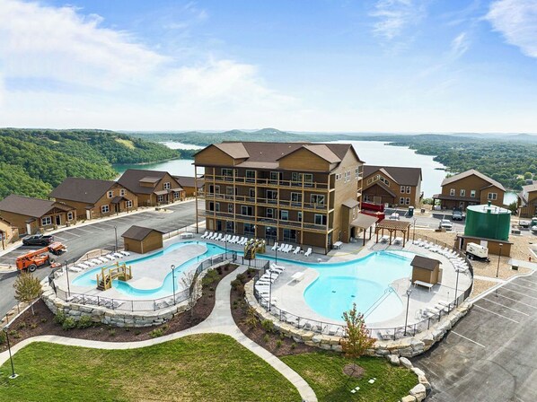 Un hôtel doté d’une grande piscine, de plusieurs bâtiments et offrant une vue sur un lac.