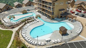 Ein Hotel mit großem Pool, mehreren Gebäuden und Seeblick.