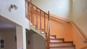 A multi-level wooden staircase with a handrail, a radiator, and a dreamcatcher on the wall. - HOSTERIA  AILEN (Ushuaia)