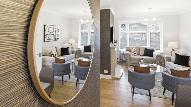 Un salón moderno con un espejo grande, dos sofás, una mesa de centro y una chimenea.
