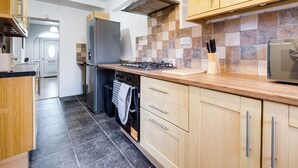 Una cocina moderna con armarios de madera, estufa a gas, horno empotrado y microondas.