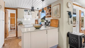 A modern kitchen with a central island, pendant lighting, and a wood stove. - "Monna" -  from the sea by Interhome (Hvide Sande)