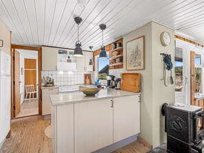 A modern kitchen with a central island, pendant lighting, and a wood stove. - "Monna" -  from the sea by Interhome (Hvide Sande)