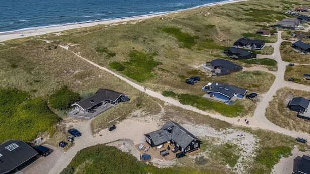 A coastal property with multiple houses, a beach, and a clear view of the ocean. - "Monna" -  from the sea by Interhome (Hvide Sande)