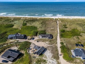 A coastal property with multiple buildings, a sandy beach, and a clear view of the ocean. - "Monna" -  from the sea by Interhome (Hvide Sande)