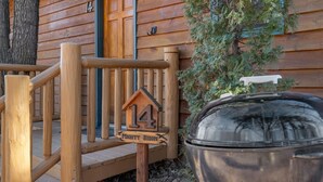 A wooden cabin with a number 14 sign, a wooden porch, and a metal lantern. - Bison Trail House: Rustic Cabin Retreat (Rapid City)