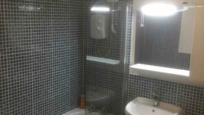 Un baño con bañera, lavamanos y ducha.