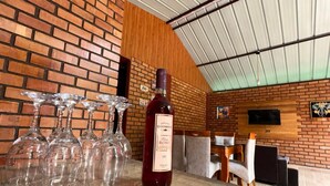 A bar area with a brick wall, a wooden ceiling, and a bottle of wine on the counter. - Country House in Tingo Maria - Adelaide Resort (Tingo María)