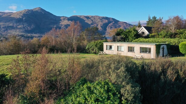Een chalet met uitzicht op bergen en een meer.
