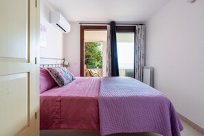 Une chambre à coucher avec un lit, une fenêtre et un appareil de climatisation.