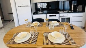Una cocina moderna con armarios blancos, encimera negra y estufa integrada.