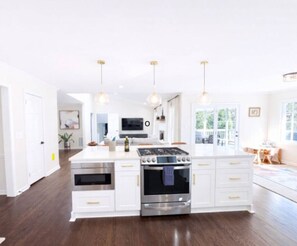 A modern kitchen with white cabinetry, stainless steel appliances, and pendant lighting. - Inside the Perimeter|Spacious-Fenced|Extended Stay (Atlanta)