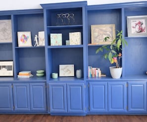 A blue shelving unit with various decorative items and books. - Inside the Perimeter|Spacious-Fenced|Extended Stay (Atlanta)