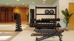 Ett gym med hantlar, en bänk och en boxningssäck.