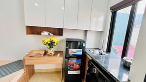 A compact kitchen with a refrigerator, a sink, and a window.