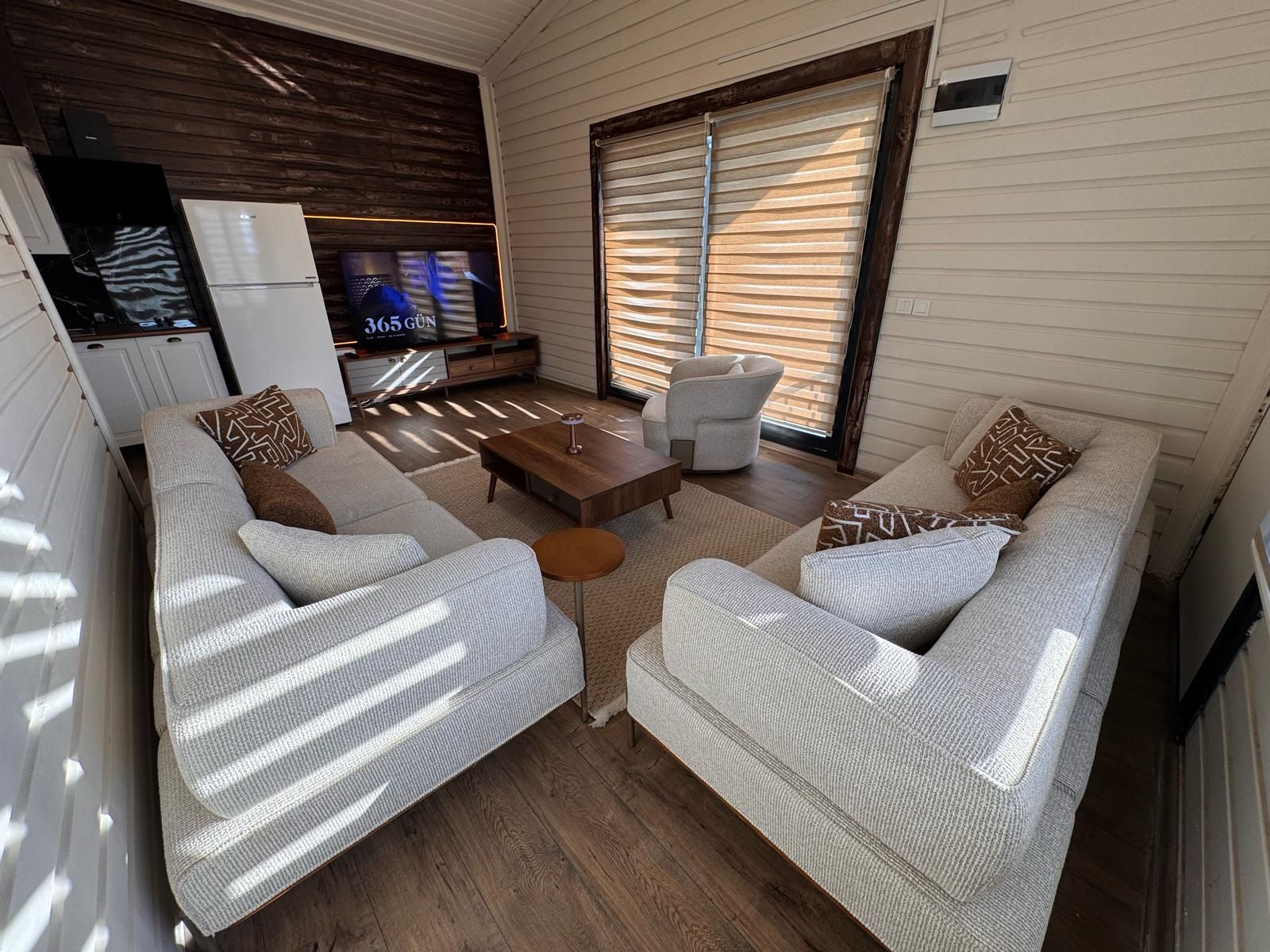 Un espacio habitable compacto con un conjunto de sofá, una mesa de centro y un televisor.