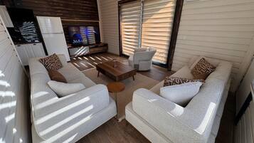 Un espacio habitable compacto con un conjunto de sofá, una mesa de centro y un televisor.