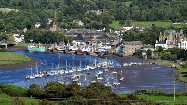 A coastal town with a marina filled with sailboats, surrounded by lush greenery and historic buildings. - Beautifully Presented Cosy Home in Kirkcudbright - Pass the Keys (Kirkcudbright)