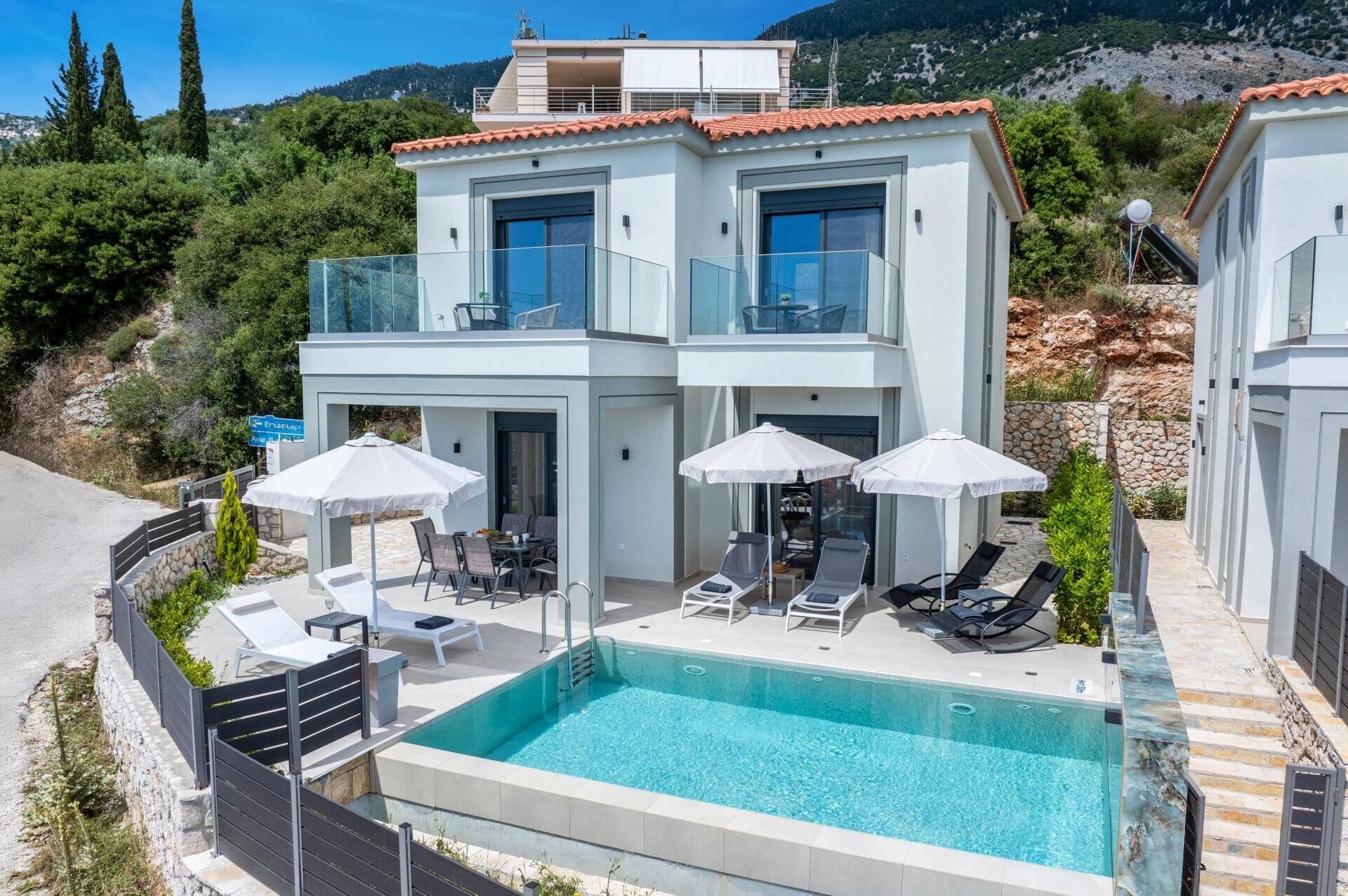 Une villa moderne à deux étages, dotée d’une piscine, d’un espace de détente extérieur et offrant une vue sur le paysage environnant.