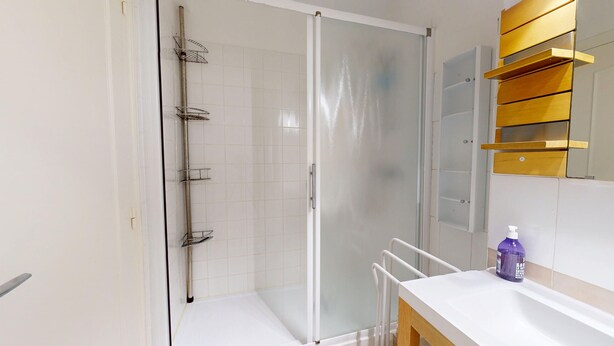 A modern bathroom with a glass shower enclosure, a white sink with a wooden vanity, and a mirror with a wooden frame. - Panorama des 5 Pineaux, total immersion facing the ocean in Saint-Hilaire-de-Riez (Saint-Hilaire-de-Riez)