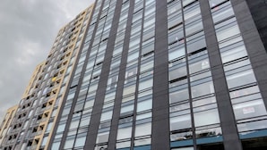 Un edificio alto y moderno con fachada de vidrio y varios balcones.