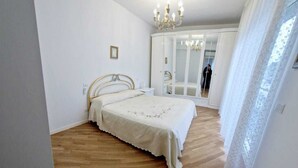 Un dormitorio con cama, armario y una lámpara de araña.