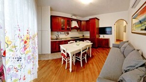 Un espacio habitable compacto con comedor, kitchenette y sofá.