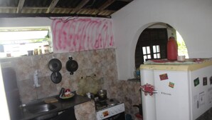 Una cocina con estufa, lavaplatos y refrigerador, que cuenta con un salpicadero de azulejos y una ventana con vistas.