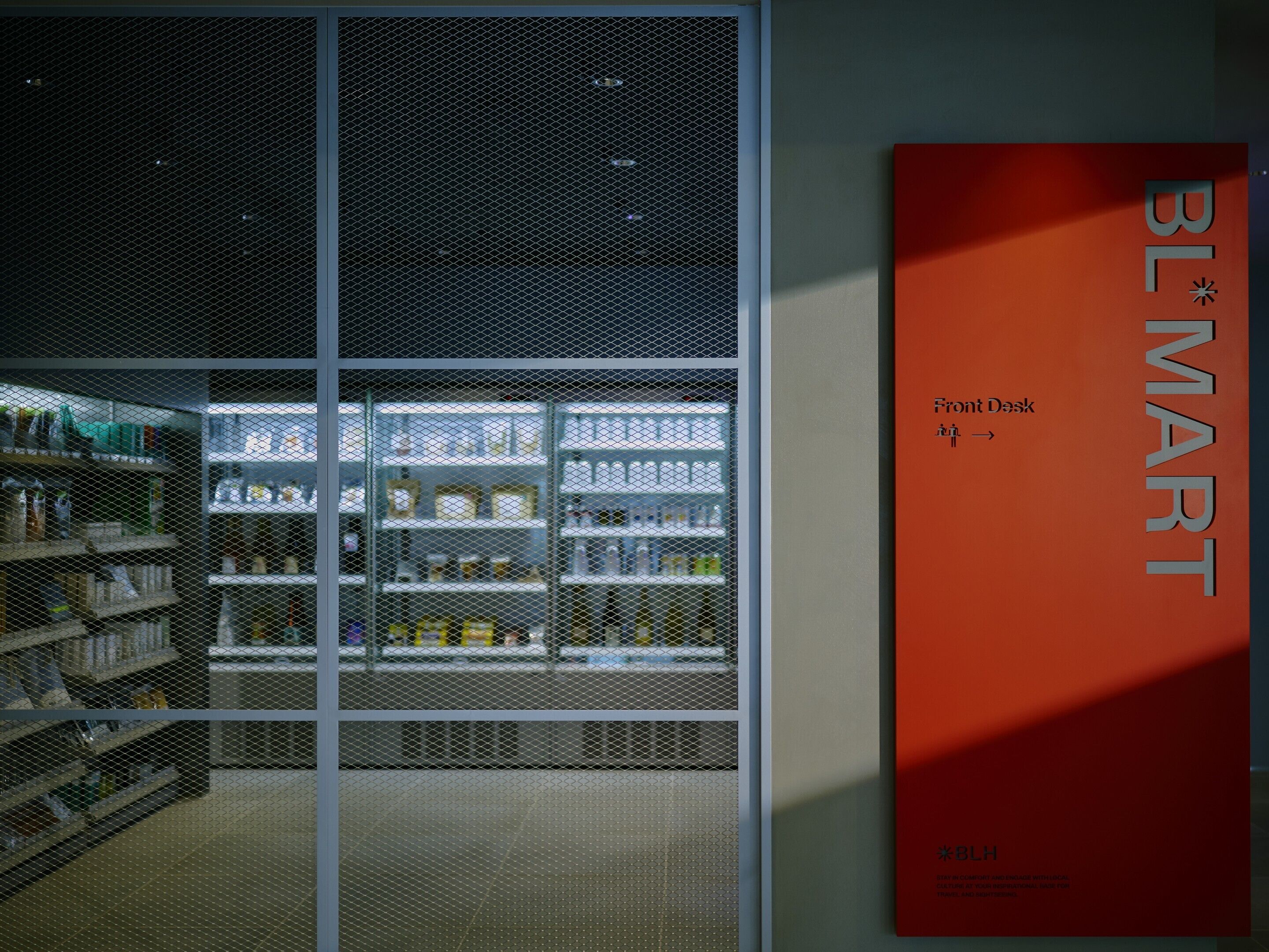 A store interior with shelves stocked with products, a front desk sign, and a BL*MT branding sign.