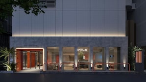 A modern hotel with a clean, grid-patterned facade and a well-lit entrance.
