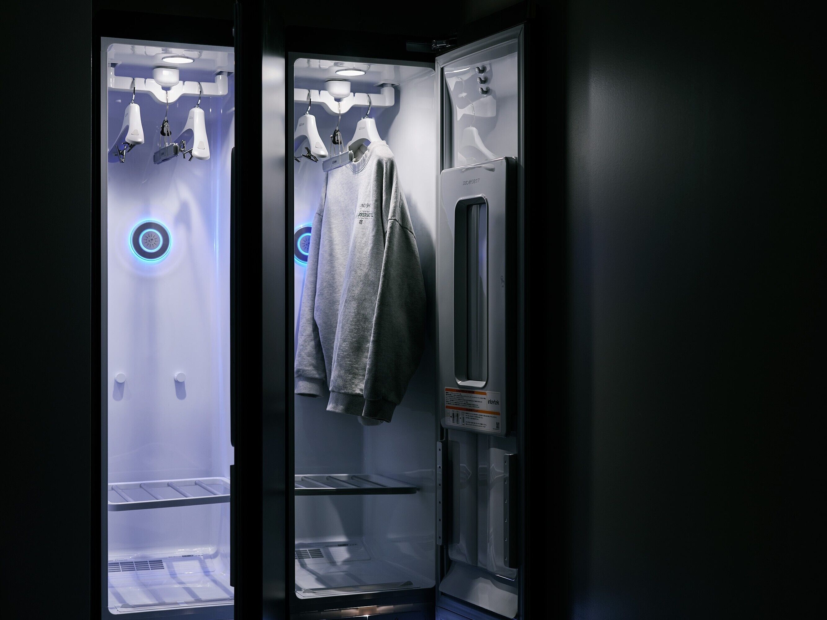 A compact, modern room with a built-in wardrobe, a mirror, and a small seating area.