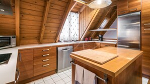 Een moderne keuken met houten kastjes, een roestvrijstalen koelkast en een houten aanrecht.