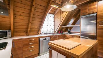 Een moderne keuken met houten kastjes, een roestvrijstalen koelkast en een houten aanrecht.