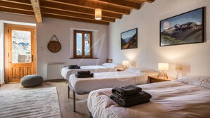 A hotel room with two beds, a wooden ceiling, a large window, and a mountain view. - Casa Unhòla by SeaMount Rentals (Unha)