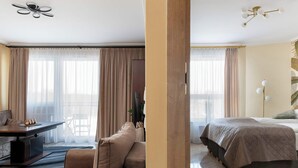 Hotellihuone, jossa on sänky, sohva, työpöytä ja tuoli.