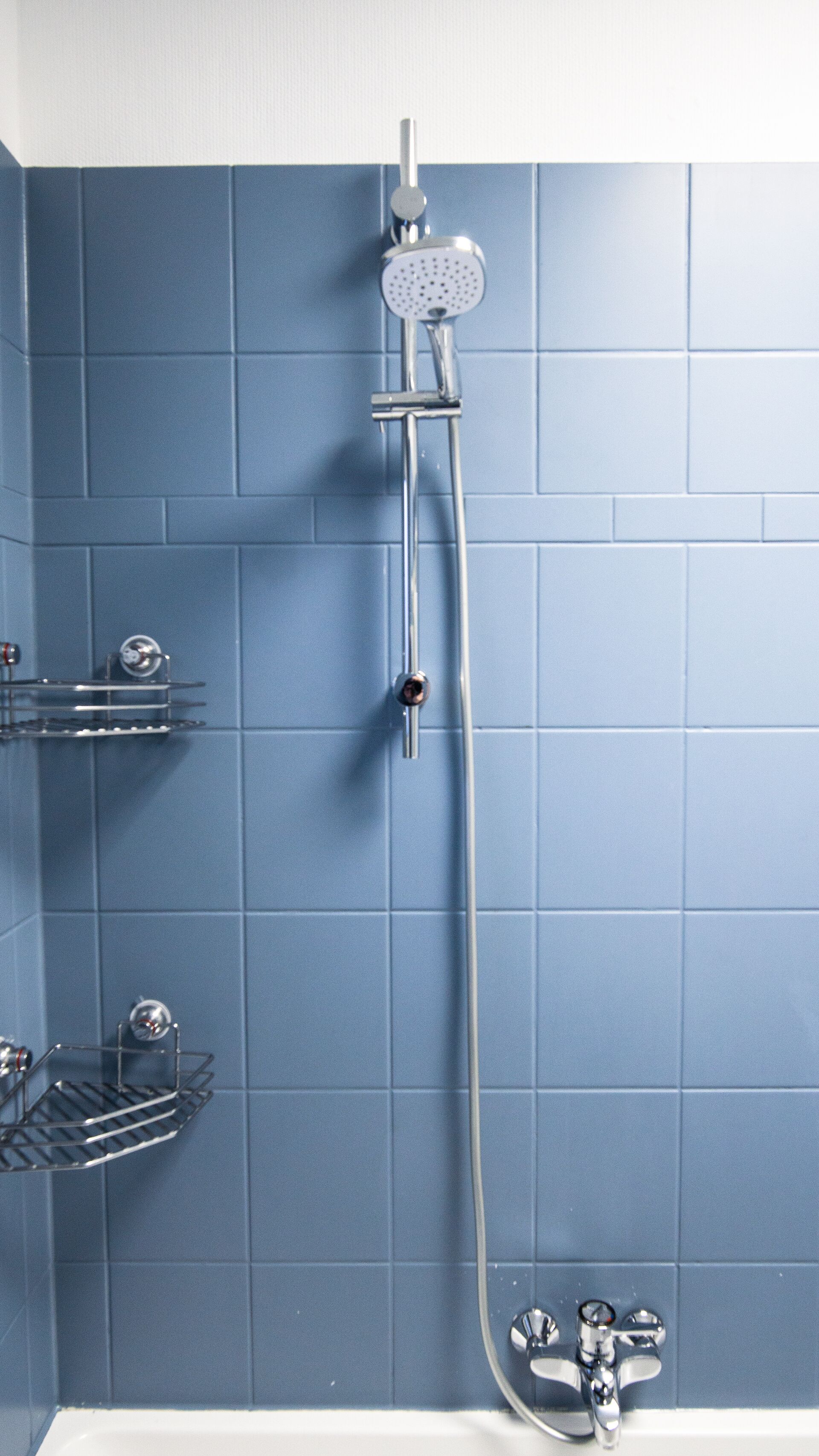 Un baño con ducha, lavabo y espejo.