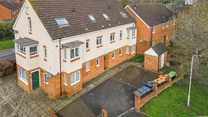 A two-story residential building with a tiled roof, a small front garden, and a parking area. - The Cosy Spot- Contractor Friendly- Free Parking (Clapham)