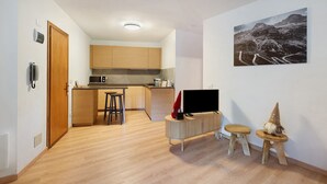 Eine moderne Küche mit Holzausstattung, einer Mikrowelle und einem Essbereich mit Hockern.