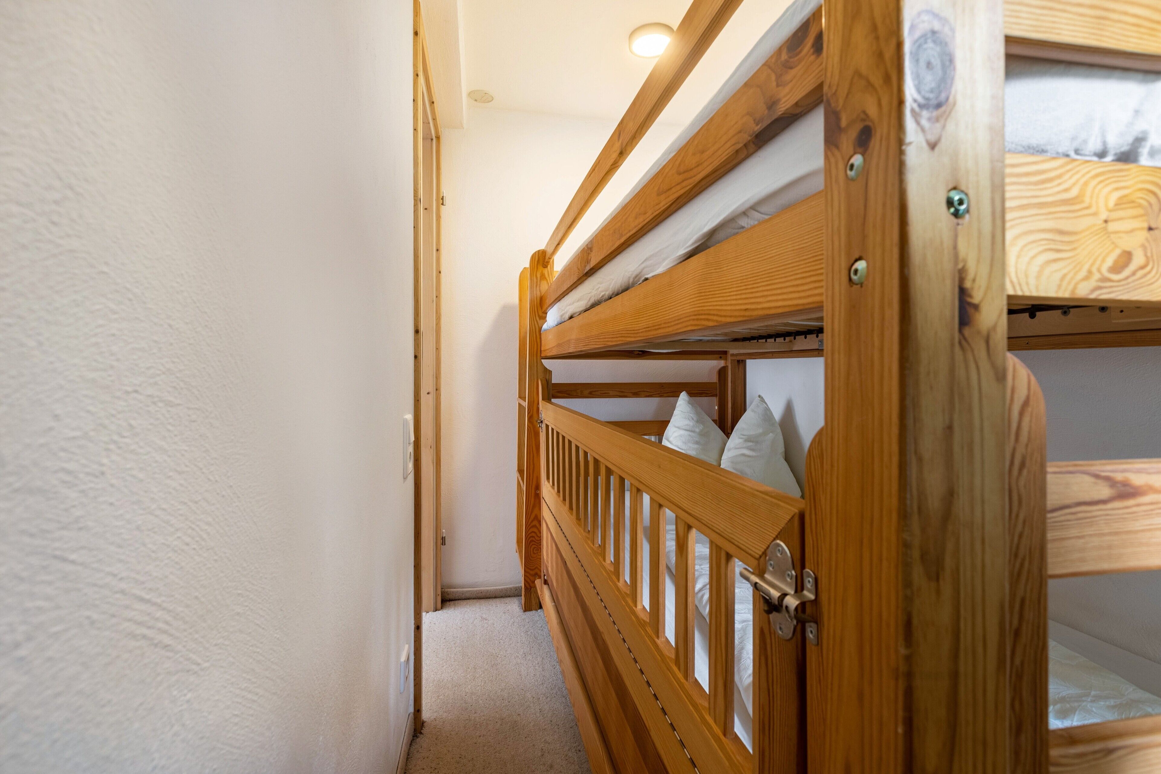 A bunk bed with a wooden frame and a mattress.