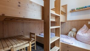 A bunk bed with a desk and chair, a teddy bear, and a shelf with books. - Apartment 'Romantik' with Shared Terrace, Balcony and Wi-Fi (Lennestadt)